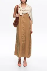 Vestido midi de corte recto color marrón, confeccionado en mezcla de lyocell y viscosa. Presenta cierre frontal con botones forrados, escote en V pronunciado con tirantes finos y detalles de encaje en el escote y los laterales.