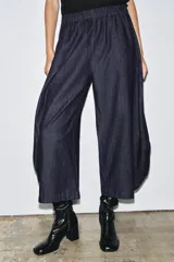 Pantalón ancho de denim azul oscuro, tiro medio, con cintura elástica ajustable mediante cordones interiores y pierna muy ancha con volumen que termina en un ruedo redondeado.