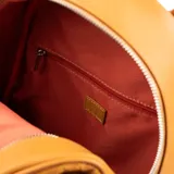 Mochila color suela de símil cuero con diseño repujado con el logo de la marca. Tiene un compartimento principal con cierre, un bolsillo interno con cierre y dos abiertos, un bolsillo externo con cierre, correa regulable y herrajes plateados. El interior es de tela de algodón y poliéster.