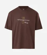 Remera boxy de algodón color marrón, con estampado trasero inspirado en Tupac y el concepto "The Rose", incluyendo texto y una imagen abstracta.