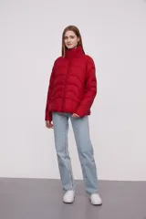 Campera roja de poliéster con diseño acolchado, cierre frontal con cremallera y cuello alto.