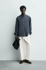 Pantalón de corte relajado confeccionado en una mezcla de algodón y lino. Presenta cintura elástica con cordón ajustable, bolsillos laterales y bolsillos traseros de vivo.