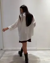 Camisa negra de manga larga con cuello clásico y cierre frontal con botones.