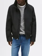 Campera negra de Tommy Hilfiger, modelo Regatta, con cuello alto, cierre de cremallera, dos bolsillos laterales y logo engomado bordado en la manga.