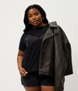 Campera estilo biker de poliuretano color marrón oscuro con efecto lavado, corte oversized, cuello con solapa, cierre frontal asimétrico y bolsillos con cierre.