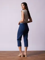 Pantalón capri blanco de algodón denim con pretina ancha elastizada, bolsillos delanteros simulados y bolsillos traseros aplicados.