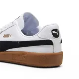 Championes Puma modelo Army Trainer, de diseño retro en color blanco con detalles en verde oscuro y suela de goma color caramelo. Presenta refuerzos de gamuza en la puntera y el logo de la marca en dorado en el lateral.