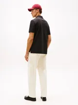 Chomba negra de manga corta con cuello clásico y tapeta de dos botones. Presenta un patrón integral con el logo de la marca y el logo bordado en la manga. Confeccionada en algodón BCI y elastolefín.