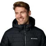 Campera acolchada negra con capucha, cierre frontal completo y bolsillos laterales con cremallera. Presenta tecnología termorreflectante en el interior y logo de la marca estampado en el pecho.