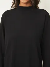 Vestido corto de cuello alto y manga larga, confeccionado en tejido de punto suave con un corte recto y holgado.