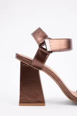 Sandalia de taco cuadrado alto, color negro, con diseño de punta cuadrada y tira ancha en el empeine. Cuenta con una tira ajustable en el tobillo con cierre metálico.