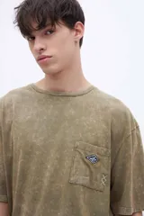 Remera celeste con efecto marmolado, bolsillo en el pecho con parche decorativo y arte en la espalda baja. De calce oversize y algodón lavado con textura extra suave.