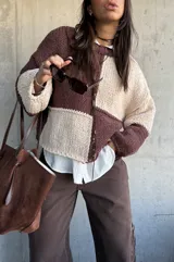 Sweater de punto con diseño de bloques de color en tonos chocolate y beige, de corte holgado y mangas largas con puños ajustados.