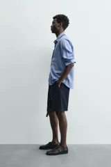 Bermuda de hombre color azul marino, de corte relajado (relaxed fit), confeccionada en tejido con textura. Presenta bolsillos frontales y bolsillos traseros de vivo, con cierre frontal de cremallera y botón.