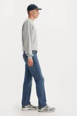 Jeans de corte regular fit en color azul medio, con diseño clásico de cinco bolsillos y cierre frontal con botón y cremallera.