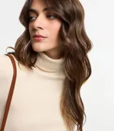 Suéter de punto color borgoña, con cuello alto estructurado y mangas largas.