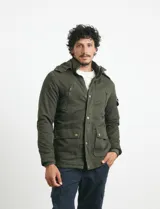 Campera de abrigo color verde militar, con capucha desmontable forrada, cierre frontal con cremallera y botones a presión. Cuenta con múltiples bolsillos: dos en el pecho con cierre, dos en la cintura con botones y un bolsillo en la manga. El interior está forrado para mayor calidez.