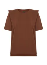 Remera de punto de algodón color terracota, de corte recto, largo estándar y mangas cortas. El diseño incluye superposiciones de tela en los hombros, creando un efecto estructurado y ligeramente geométrico. El cuello redondo presenta ribete acanalado y los laterales tienen pequeñas aberturas para un mejor ajuste.