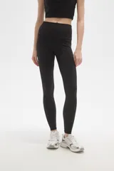 Calza deportiva de poliamida, color negro, con diseño al cuerpo y cintura alta.