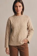 Sweater de punto con diseño de trenzas verticales, cuello redondo y corte oversize. Presenta puños y ruedo acanalados anchos.