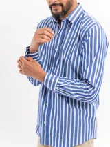 Camisa de manga larga con estampado de rayas verticales en azul y blanco, cuello clásico y cierre frontal de botones.