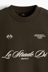 Buzo verde militar de corte oversized, confeccionado en mezcla de algodón con cuello redondo, puños y dobladillo acanalados. Cuenta con estampados en el frente, la espalda y las mangas, incluyendo inscripciones y estrellas.