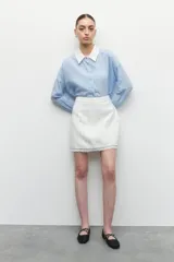 Minifalda de tweed color blanco con flecos en el ruedo.
