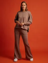 Buzo blanco de tejido elastizado, con pespunte central en la parte delantera y tajos laterales.