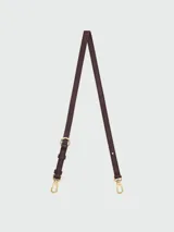 Correa de hombro ajustable para cartera Longchamp, confeccionada en cuero color marrón con herrajes metálicos dorados.