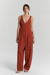 Entero color terracota con escote en V profundo y breteles anchos. La parte superior es ajustada y la parte inferior es un pantalón ancho con pliegues en la cintura.