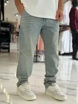 Pantalón de jean gris con efecto deslavado, corte baggy y diseño holgado.