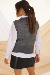 Chaleco de tejido de punto con lurex plateado, cuello redondo y sin mangas.