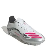 Championes de fútbol Adidas modelo F50 Messi Club, diseñados para terreno firme y césped artificial. Presentan una capellada sintética en color blanco con detalles en plateado, negro y fucsia, incluyendo el logo de Messi en el lateral y las icónicas tres tiras de la marca.