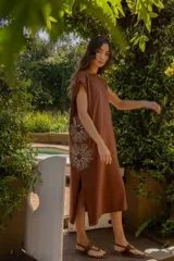 Vestido largo color gris con bordado floral blanco, sin mangas y corte holgado.