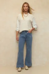 Pantalón de jean negro, ancho, de tiro alto y con dobladillo en las terminaciones.