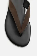 Sandalia marrón de piel con acabado serraje en el empeine, plantilla de piel y suela plana a tono.