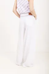Pantalón de lino blanco de tiro alto, corte wide leg y bolsillos delanteros tipo ojal.