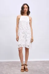 Vestido corto blanco de broderie con breteles finos y corte recto.