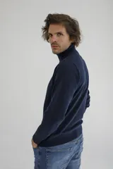 Sweater de cuello alto en color tostado, confeccionado en tejido de punto con textura en el panel frontal y mangas lisas. Presenta puños y ruedo acanalados.