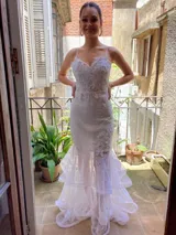 Vestido blanco de corte sirena, con breteles finos y apliques bordados en el corset y al costado.