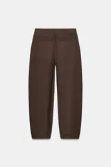 Pantalón de tiro medio con diseño barrel, pernera holgada que se estrecha hacia el tobillo, bolsillos delanteros y bolsillos de plastrón en la espalda. Confeccionado en tejido con textura de espiga, cuenta con cierre frontal de cremallera, botón interior y gancho.