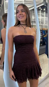 Vestido corto strapless de encaje color bordó, con diseño ajustado al cuerpo y falda con volados en el ruedo.