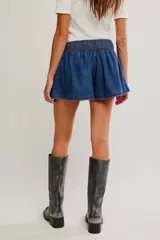 Falda pantalón de denim azul, de tiro medio y línea A, con short interno y bolsillos laterales.