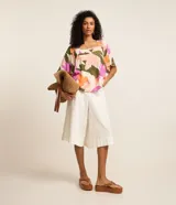 Blusa de mangas cortas con escote cuadrado y estampado floral en tonos rosa, naranja, verde y blanco.