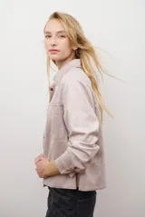 Chaqueta color camel con cuello camisero, cierre frontal con botones dorados, dos bolsillos de parche en el pecho y costuras decorativas en contraste.