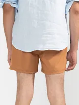 Short de baño para hombre color azul marino, con calce relajado y una tira lateral blanca estilo tuxedo. Presenta cintura elástica con cordón regulable, bolsillos laterales y trasero con cierre.