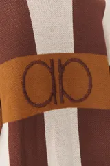 Cardigan de punto con diseño de bloques de color en tonos marrón, beige y verde. Presenta cuello redondo, cierre frontal con botones, mangas largas con hombros caídos y logo bordado en el frente. Posee terminaciones en rib a rayas.