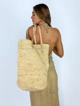 Bolso de rafia color beige con asas de cuero color suela.