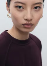 Buzo de cuello redondo y manga larga con diseño recto y holgado, confeccionado en tejido de punto suave.