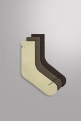 Pack de tres pares de calcetines de caña media con tejido de canalé y mezcla de algodón, en tonos tostado, verde militar y marrón oscuro. Cuentan con detalles de texto estampado en la planta y lateral.